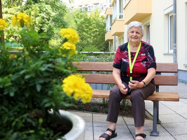 Seniorin genießt den idyllischen Garten im hesena Domizil am Ostplatz in Leipzig